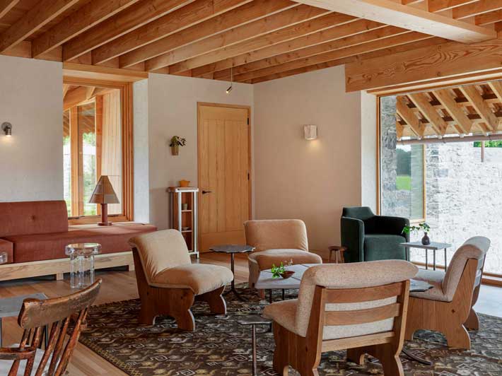 Cozy living room with wooden beams, furniture, and a decorative rug.